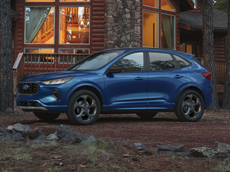 The 2023 Ford Escape parked in front of a cabin.