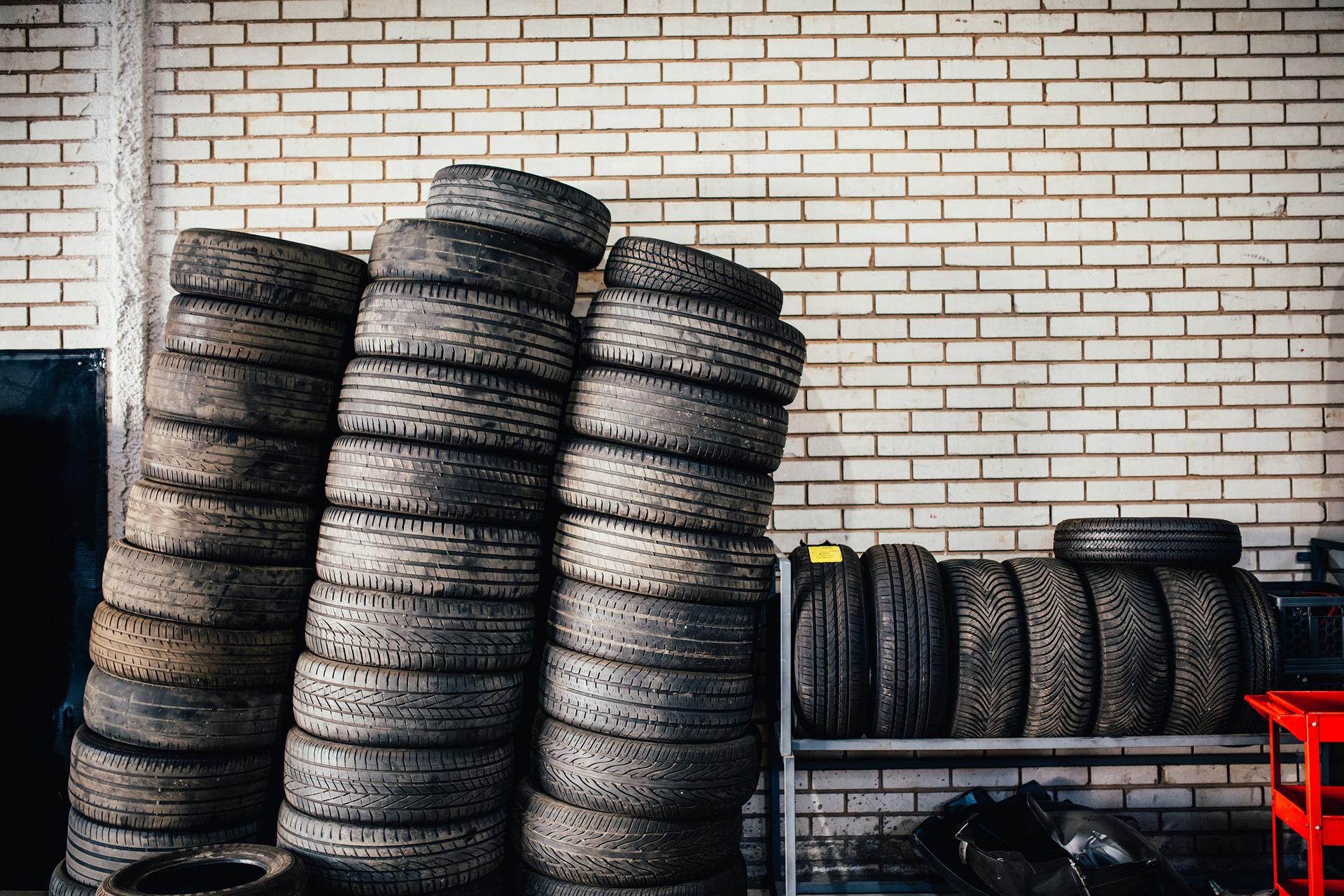 Three stacks of tires against a brick wall background