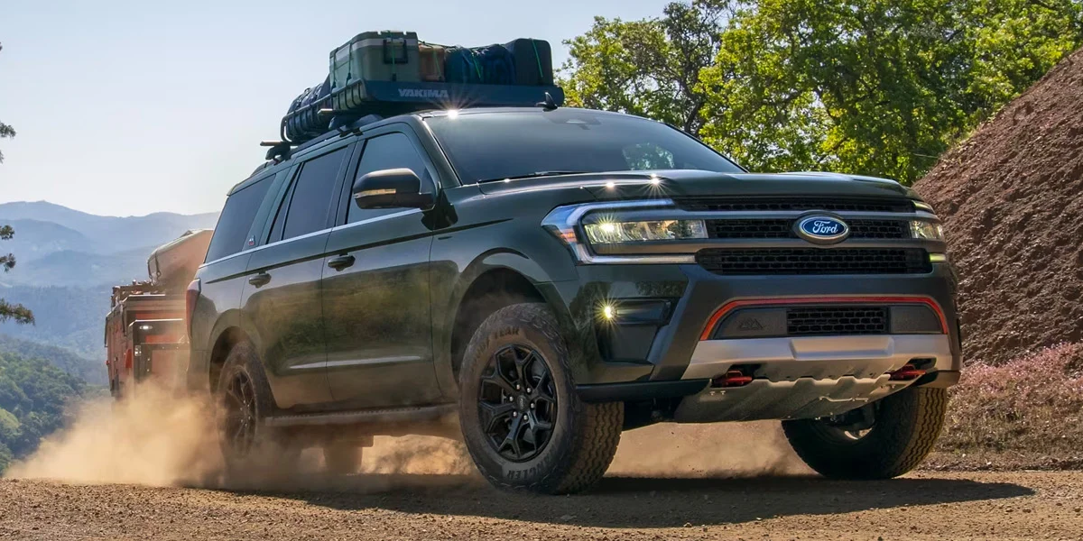 The 2024 Ford Expedition driving up a dusty trail in the forest