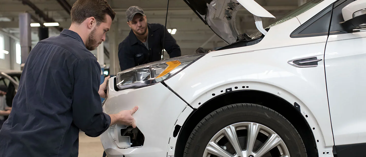 A Ford technician working on a vehicle