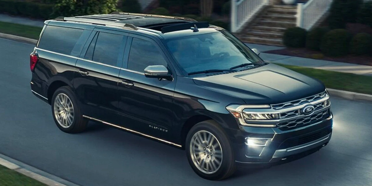 The 2025 Ford Expedition driving at dusk with headlights on
