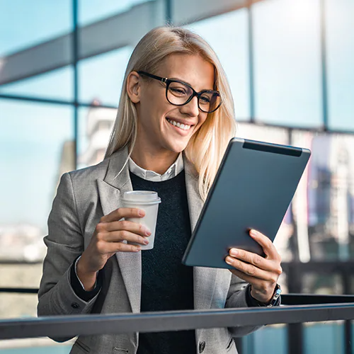 A woman smiling at her tablet